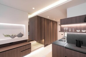 Une cuisine moderne avec des meubles en bois, une étagère intégrée pour les verres et un plan de travail élégant.