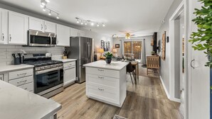 A modern kitchen with white cabinetry, stainless steel appliances, and a central island. - Right on the River! Mtn Cabin w/ Deck & Fireplace (Shawnee)