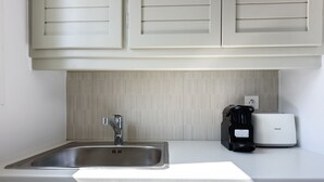 A kitchen with a stainless steel sink, a coffee maker, and a toaster. - Phaedrus Living: Paros Cycladic Residences 5 (Paros)