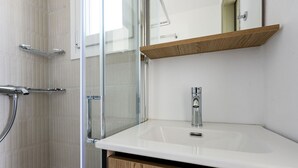 A bathroom with a shower, a sink, and a mirror. - Phaedrus Living: Paros Cycladic Residences 5 (Paros)
