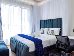 Una camera d'albergo moderna con un letto grande, una scrivania e una sedia.