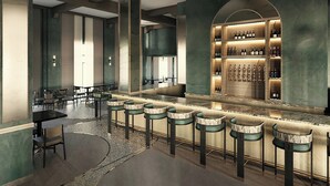 A bar area with a long counter and multiple stools, surrounded by high-backed chairs and a wine display. - GULFSTREAM HOTEL, Lake Worth Beach, a Tribute Portfolio Hotel (Lake Worth)