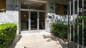 A modern building entrance with a glass door, a metal gate, and a staircase leading inside. - notaMi - Simply Six (Milan)