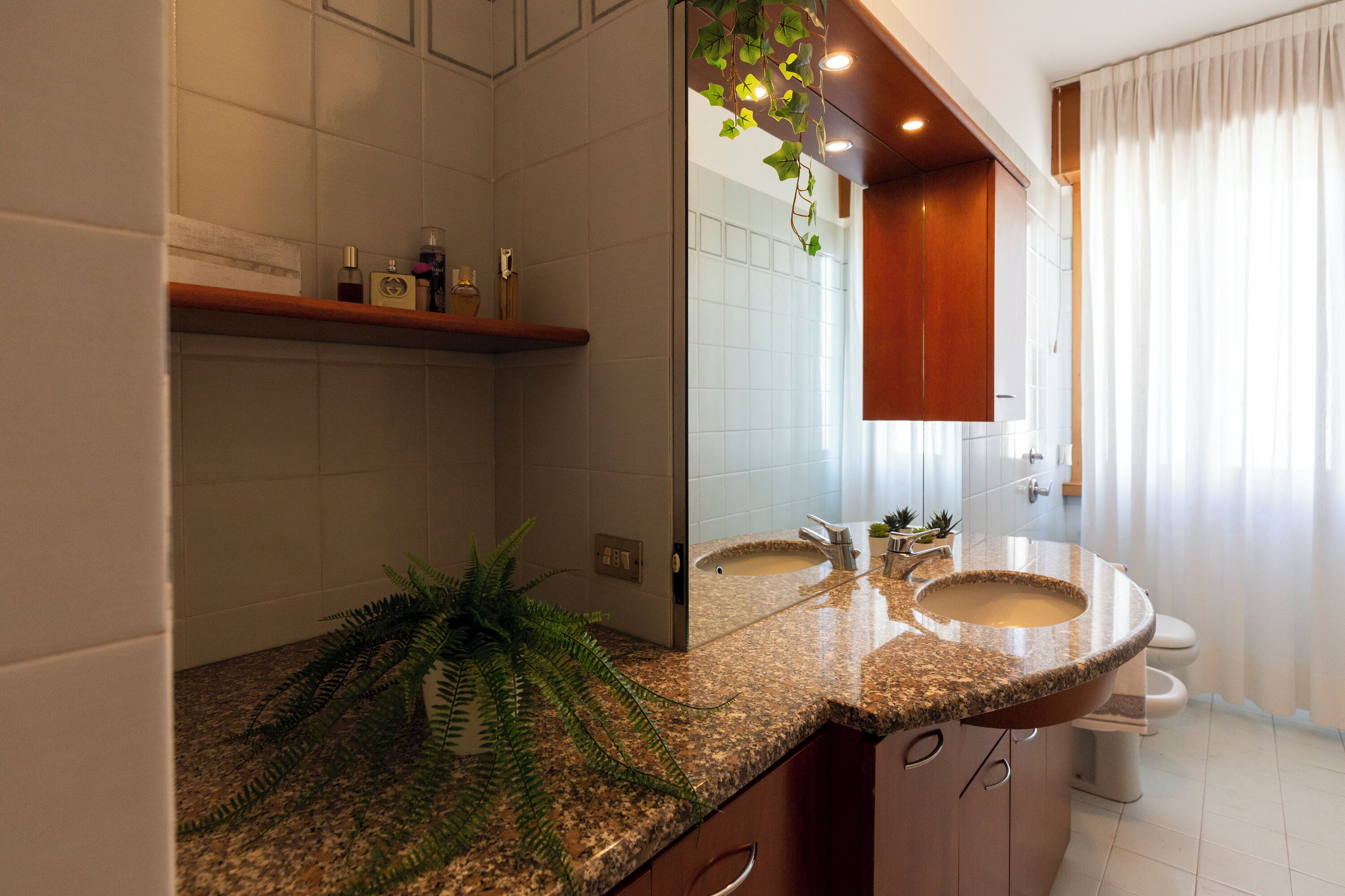Ein Badezimmer mit zwei Waschbecken, einem Spiegel und einer Dusche.