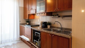 A kitchen with wooden cabinets, a granite countertop, a built-in dishwasher, and a stainless steel sink. - notaMi - Simply Six (Milan)