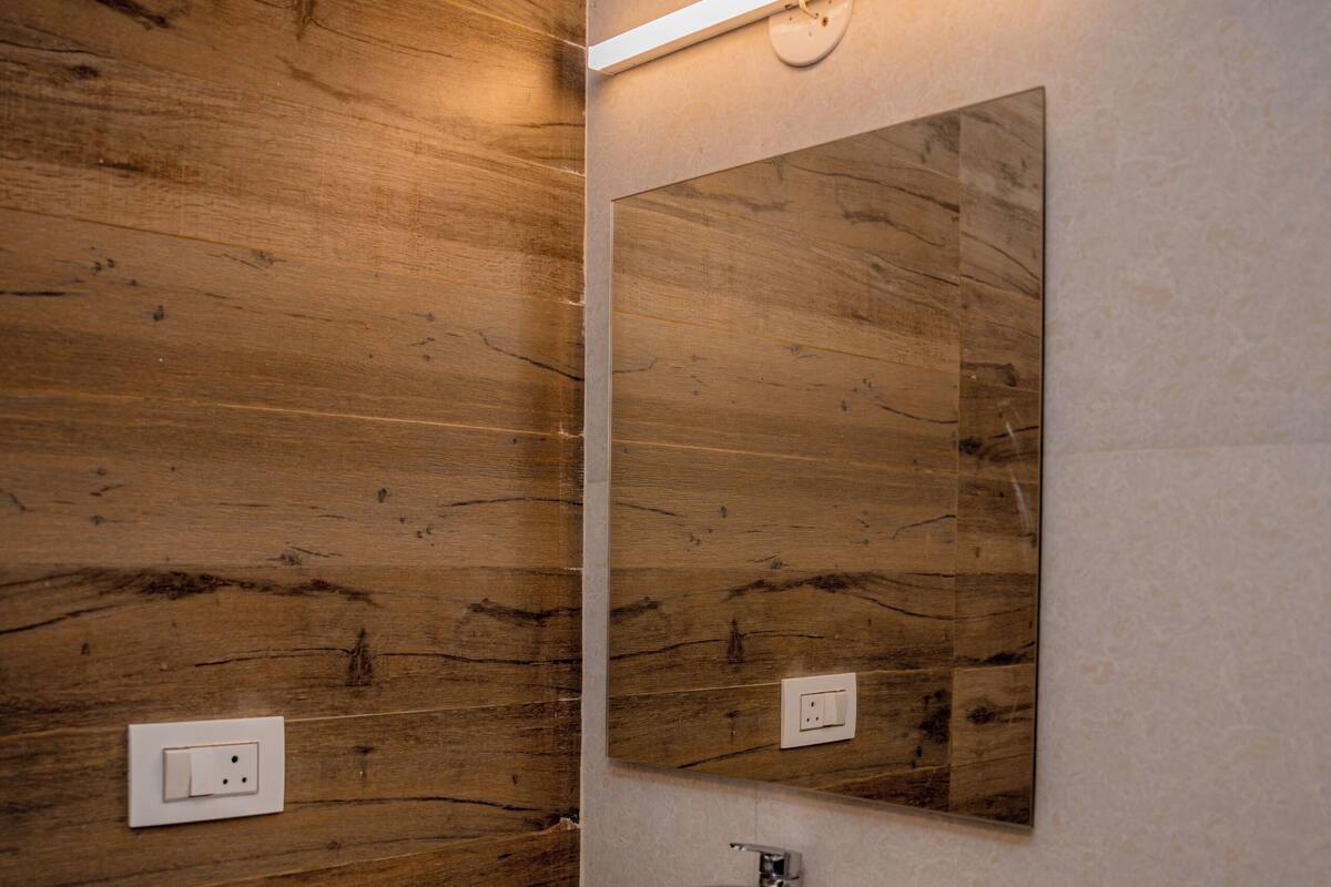 A bathroom with a wooden wall, a white sink, and a mirror.