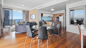 A modern interior with a dining area, kitchen, and a balcony with a view.