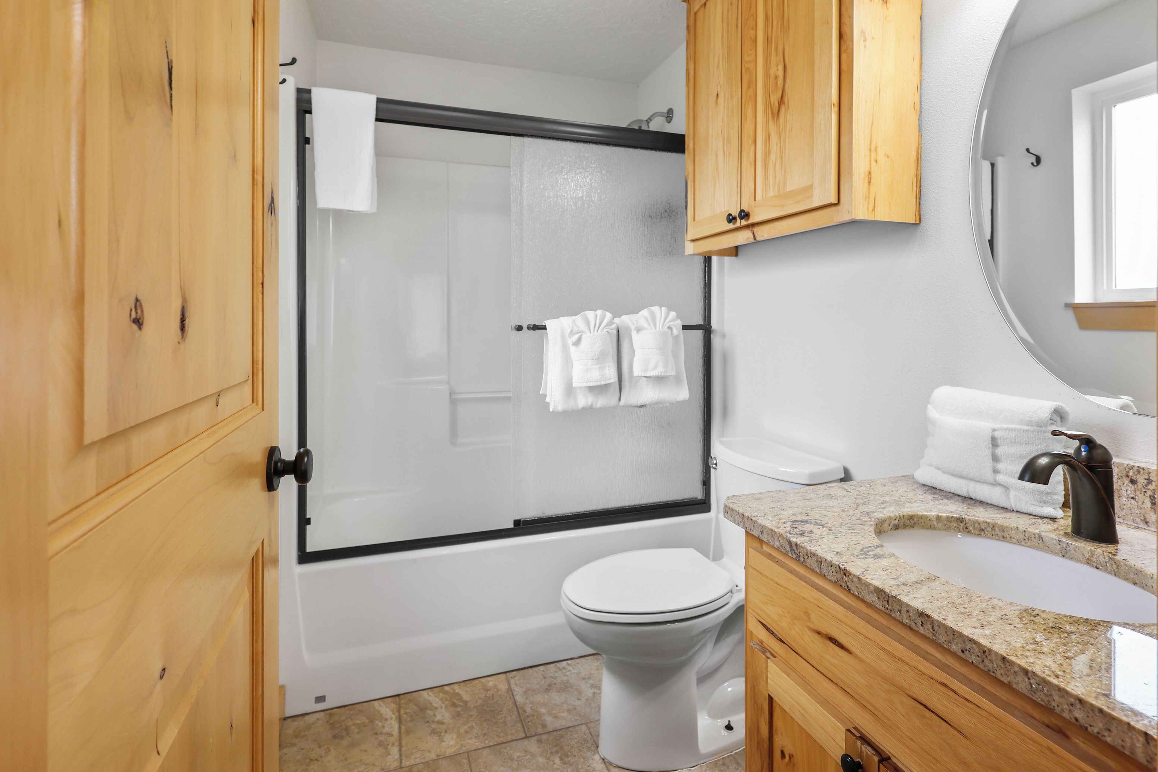 A bathroom with a shower, toilet, and sink.