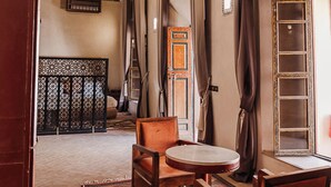 A room with a patterned ceiling, a chandelier, a round table, and a sofa. - Le Riad Medina Privilège & Spa (Marrakech)