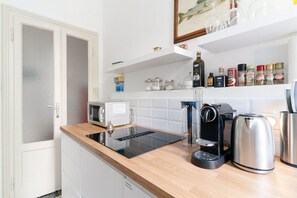 Une cuisine moderne équipée d’un four à micro-ondes encastré, d’une machine à café, d’une bouilloire et d’un moulin à café.