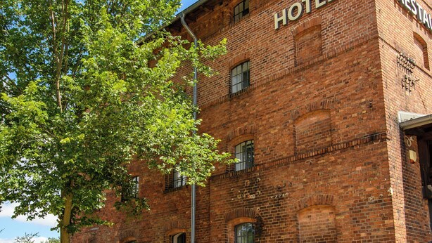 A historic brick building with a sign reading "HOTEL RESTAURANT" on the side. - Hotel Stadtgut (Berlin)