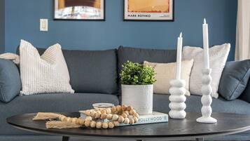 A round table with a book, a potted plant, and two candle holders.