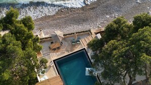 An aerial view of a resort with a swimming pool, lounge chairs, and a beach. - SeiSensi Luxury Beach Villa (Bar)