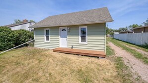 A small, single-story house with a front porch and a door.