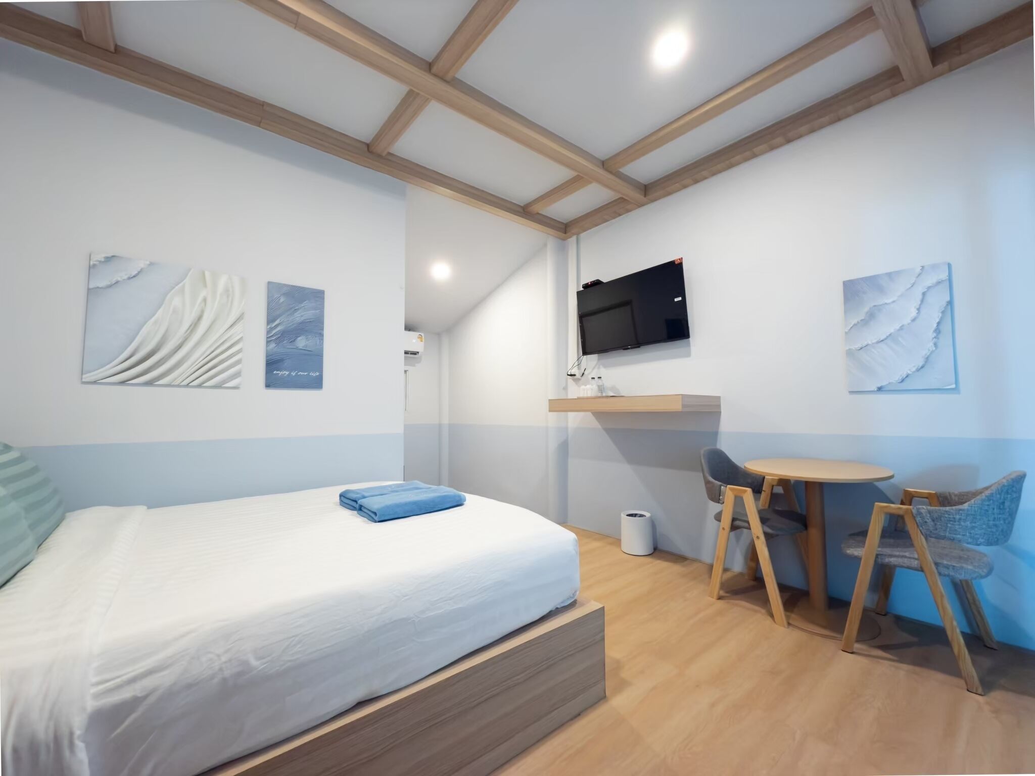 Una habitación moderna con una cama, un escritorio y un televisor.