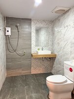 Un baño moderno con ducha, inodoro y lavamanos.