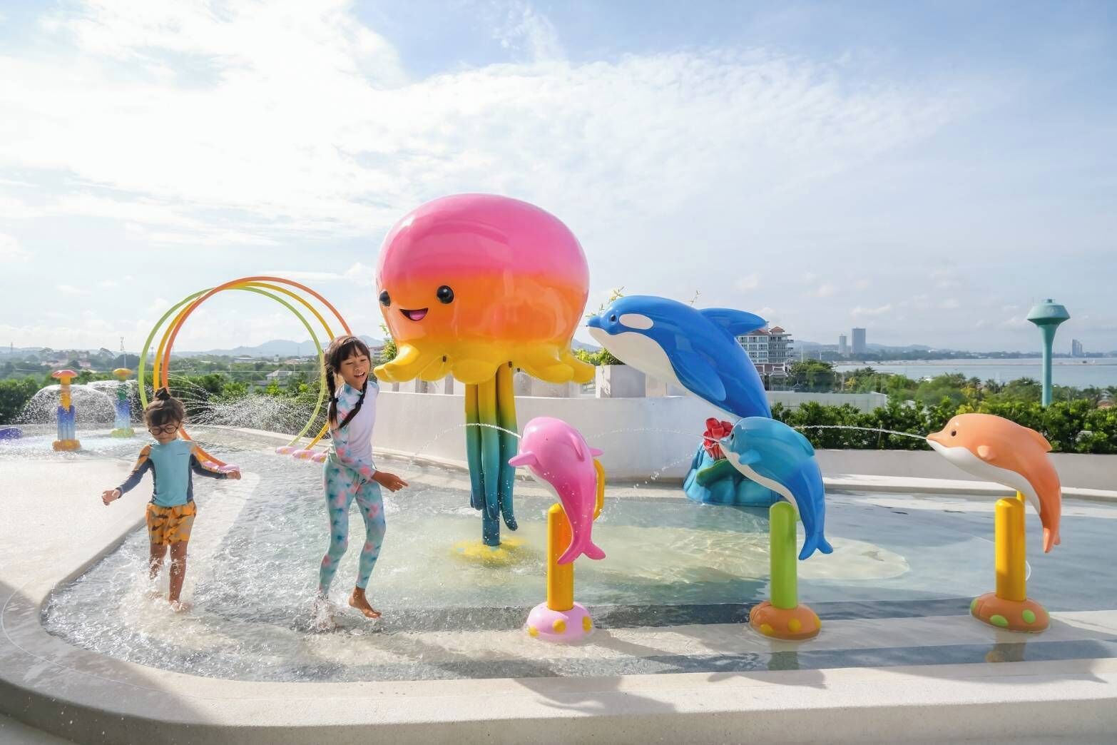 A water play area with various animal-shaped water features and a child playing.