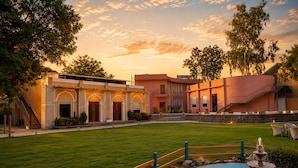 A courtyard with a fountain, a pool, and a building with arched doorways. - Kadamb Kuteer Vrindavan (Mathura)