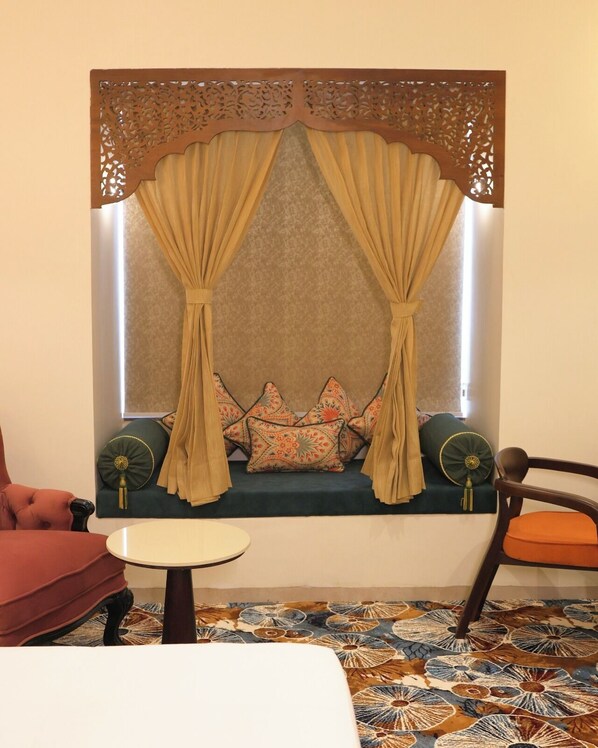 A cozy seating area with a cushioned bench, a small round table, and a decorative wall panel.