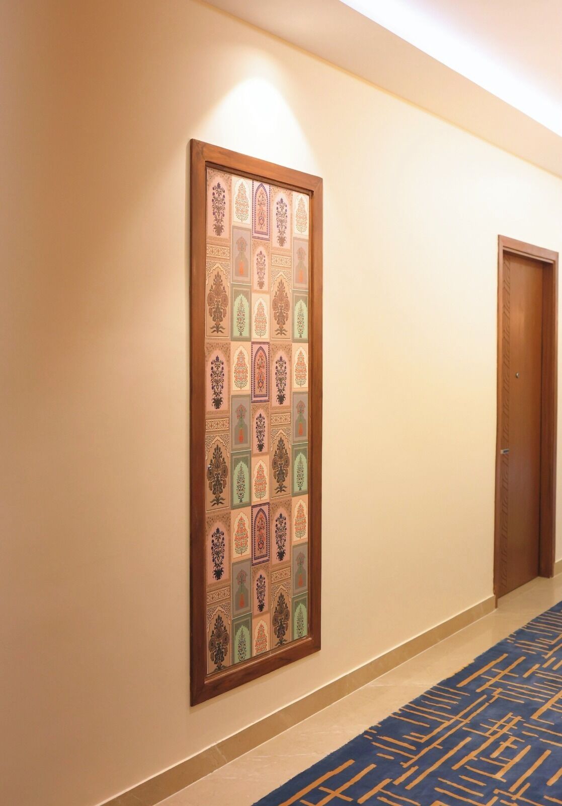 Un pasillo con decoración de pared estampada y suelo alfombrado.