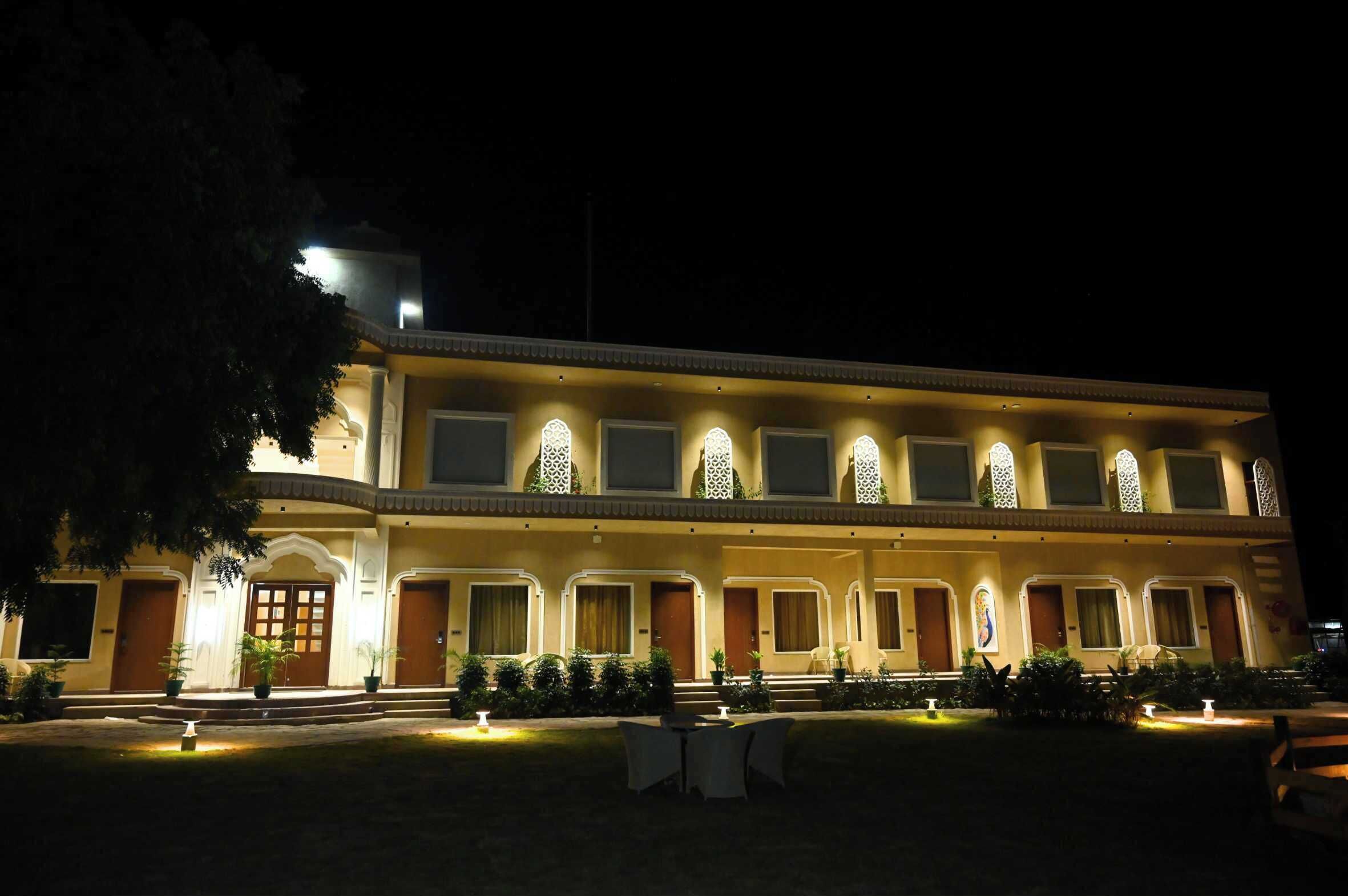 A multi-story hotel with a symmetrical facade, multiple balconies, and a well-lit entrance.