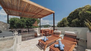 An outdoor patio with wooden lounge chairs, a sofa, and a dining table. - Casa del Espiritu Santo - La Santisima Cartagena (Unknown)
