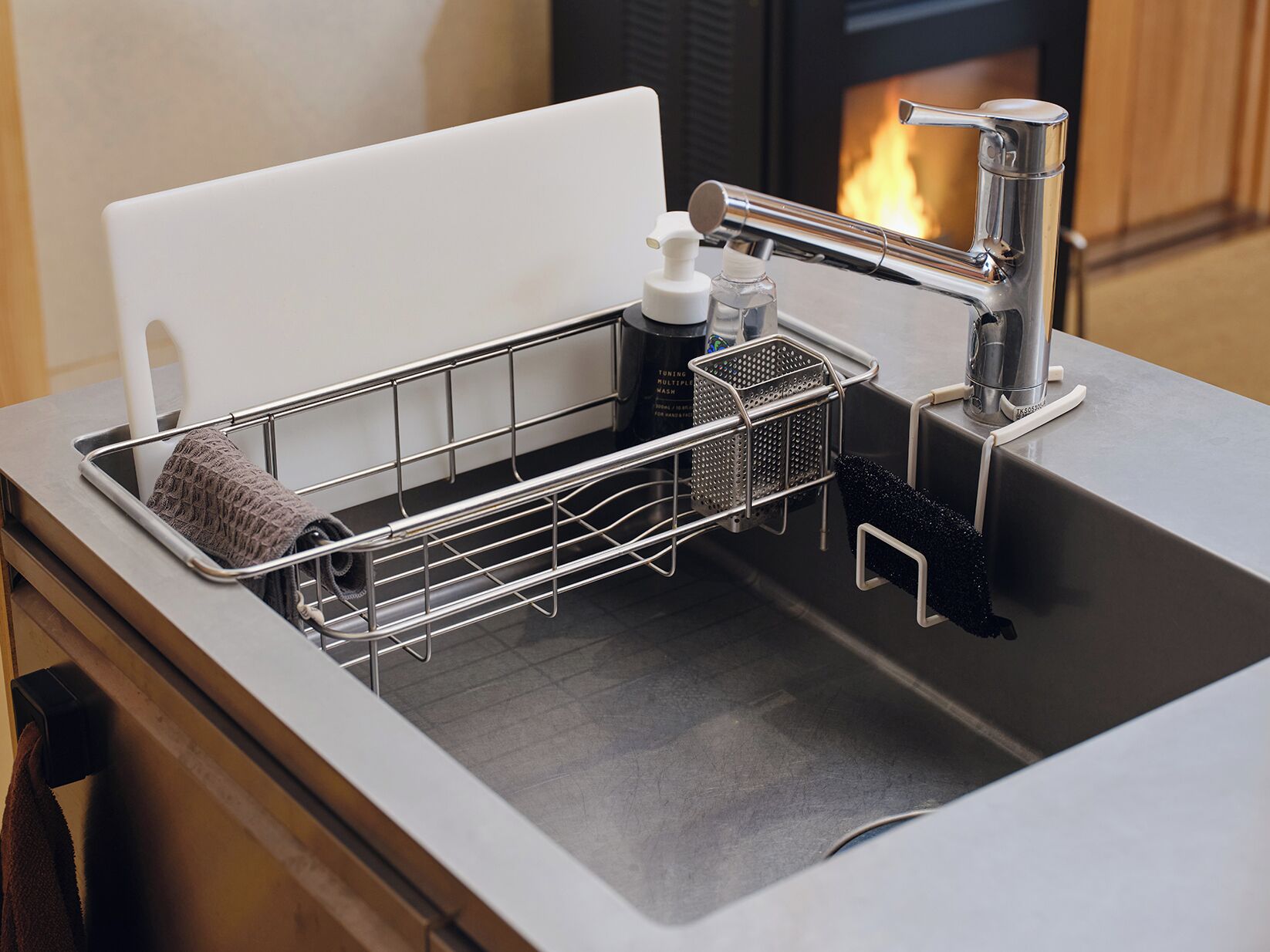Un évier de cuisine avec un égouttoir à vaisselle, un distributeur de savon et une machine à café.