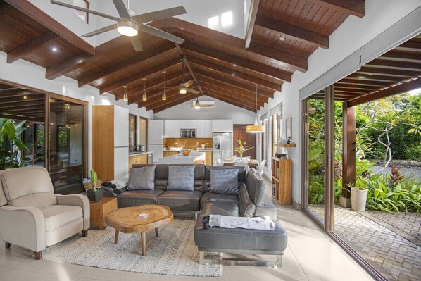 A modern living room with a sofa, coffee table, and a ceiling fan.