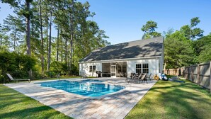A house with a swimming pool, patio furniture, and a fenced yard. - Pawleys Island Retreat with Private Pool (Pawleys Island)
