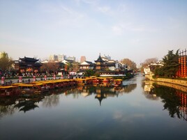 Un pintoresco pueblo tradicional chino con barcos y edificios a lo largo del río.