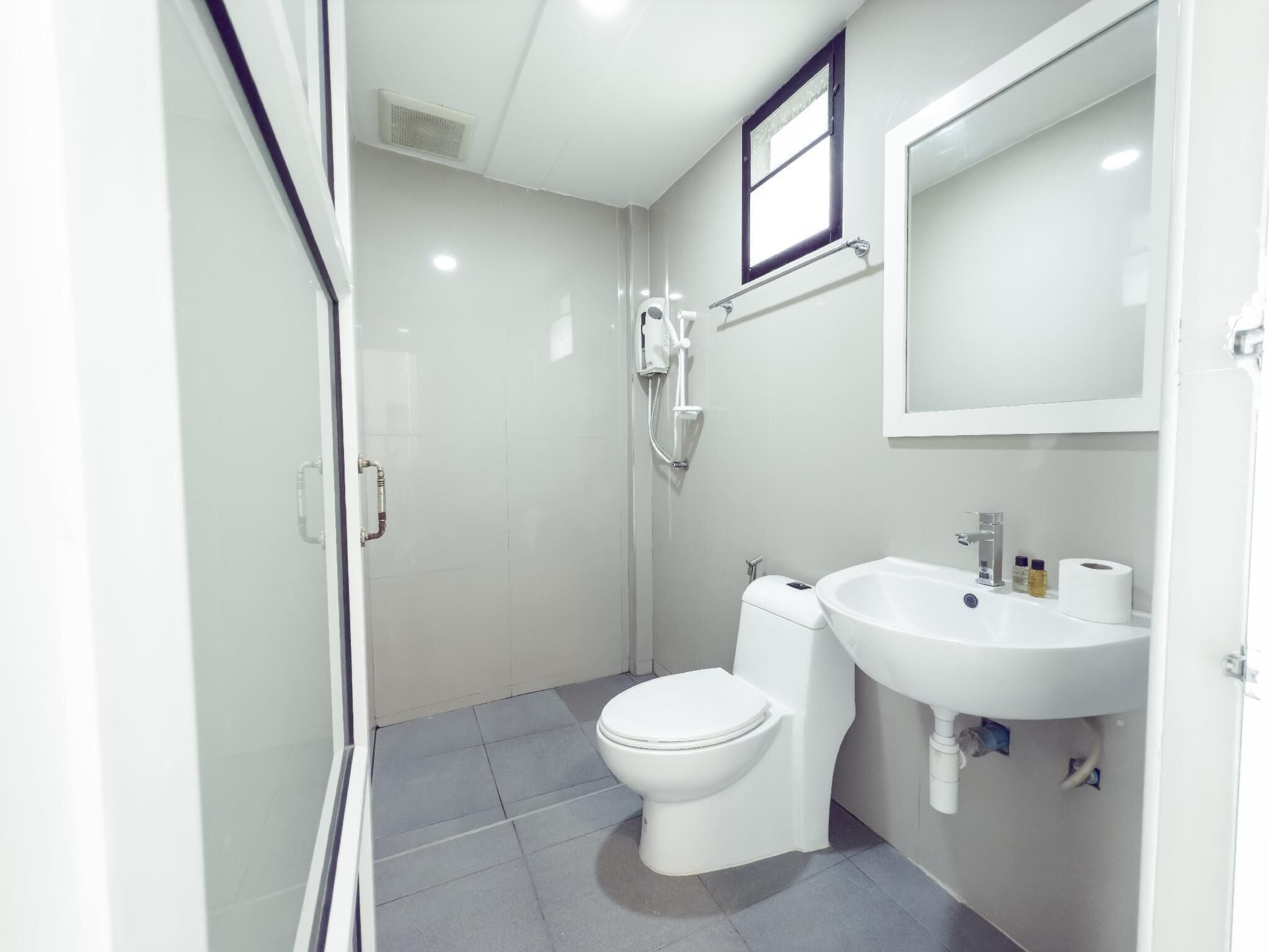 Ein kleines, modernes Badezimmer mit Toilette, Waschbecken und Dusche.