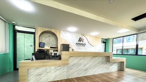 En receptionsdisk med en marmorskiva, en träbeklädd bardisk och en logotyp för ”AMIGO KOHLARN”.