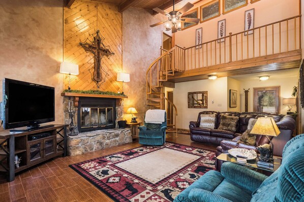 A spacious living room with a fireplace, a television, and a cozy seating area.