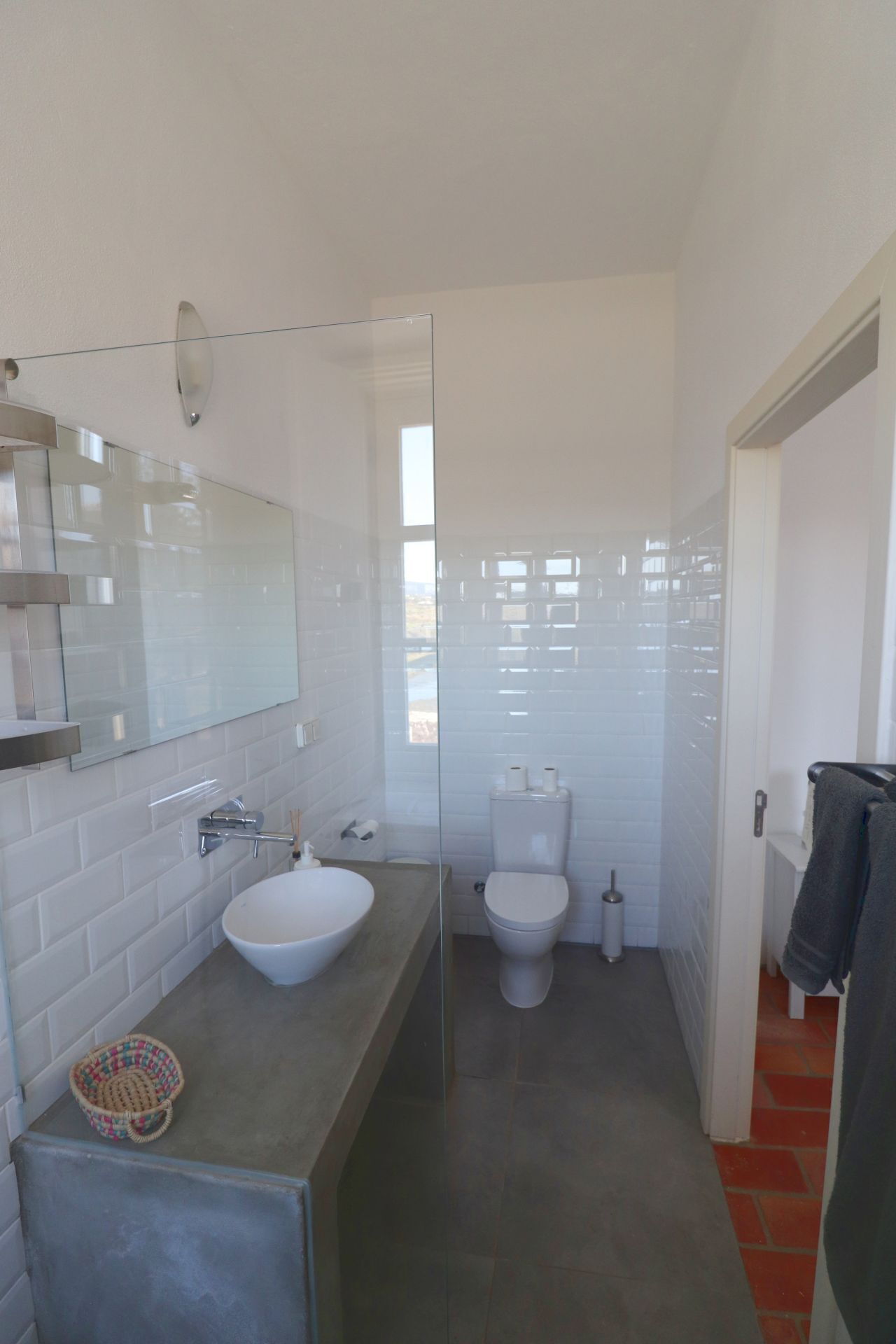 Une salle de bain moderne avec une douche à parois de verre, un lavabo blanc et des toilettes.