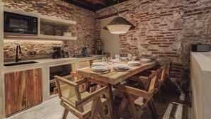 A rustic kitchen with exposed brick walls, wooden furniture, and modern appliances. - Son's House - La Santisima Cartagena (Cartagena de Indias)