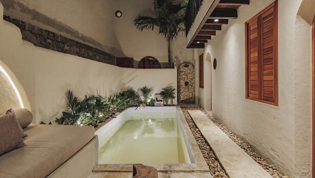 A pool area with a stone-lined edge, a sofa, and a staircase leading to an upper level. - Son's House - La Santisima Cartagena (Cartagena de Indias)