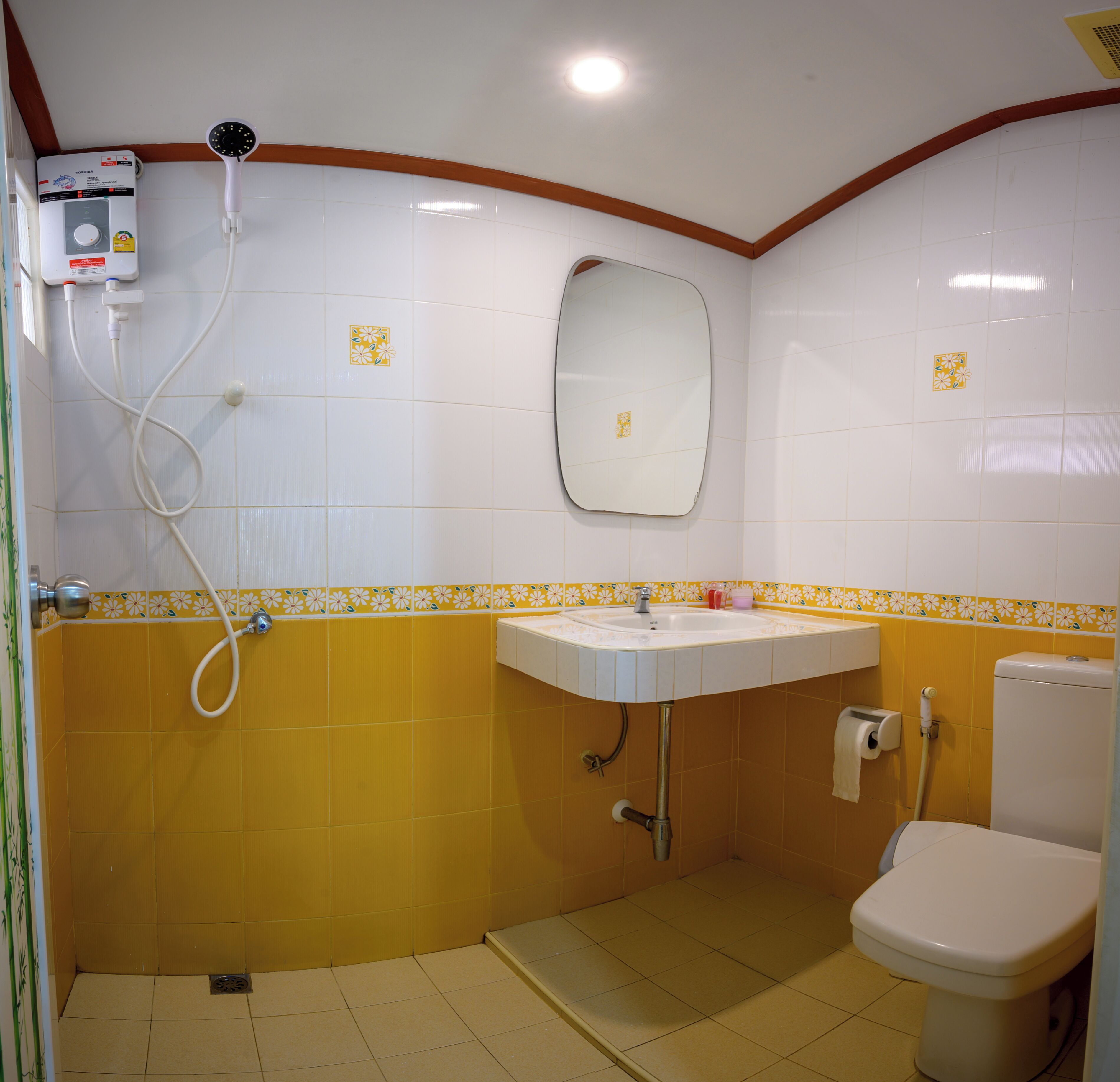 A small bathroom with a toilet, sink, and shower.