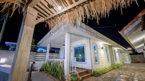 A house with a covered porch, a tiled patio, and a small garden with plants and a decorative fountain. - Halo Sea Kohlarn (Koh Lan)