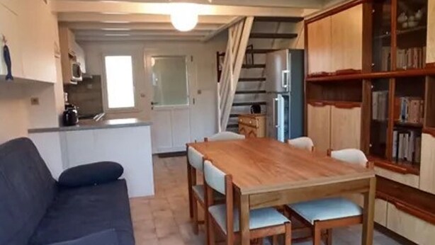 A compact living space with a dining area, kitchenette, and a staircase leading to another level. - 50m² House near beach in Le Croisic with parking (Le Croisic)