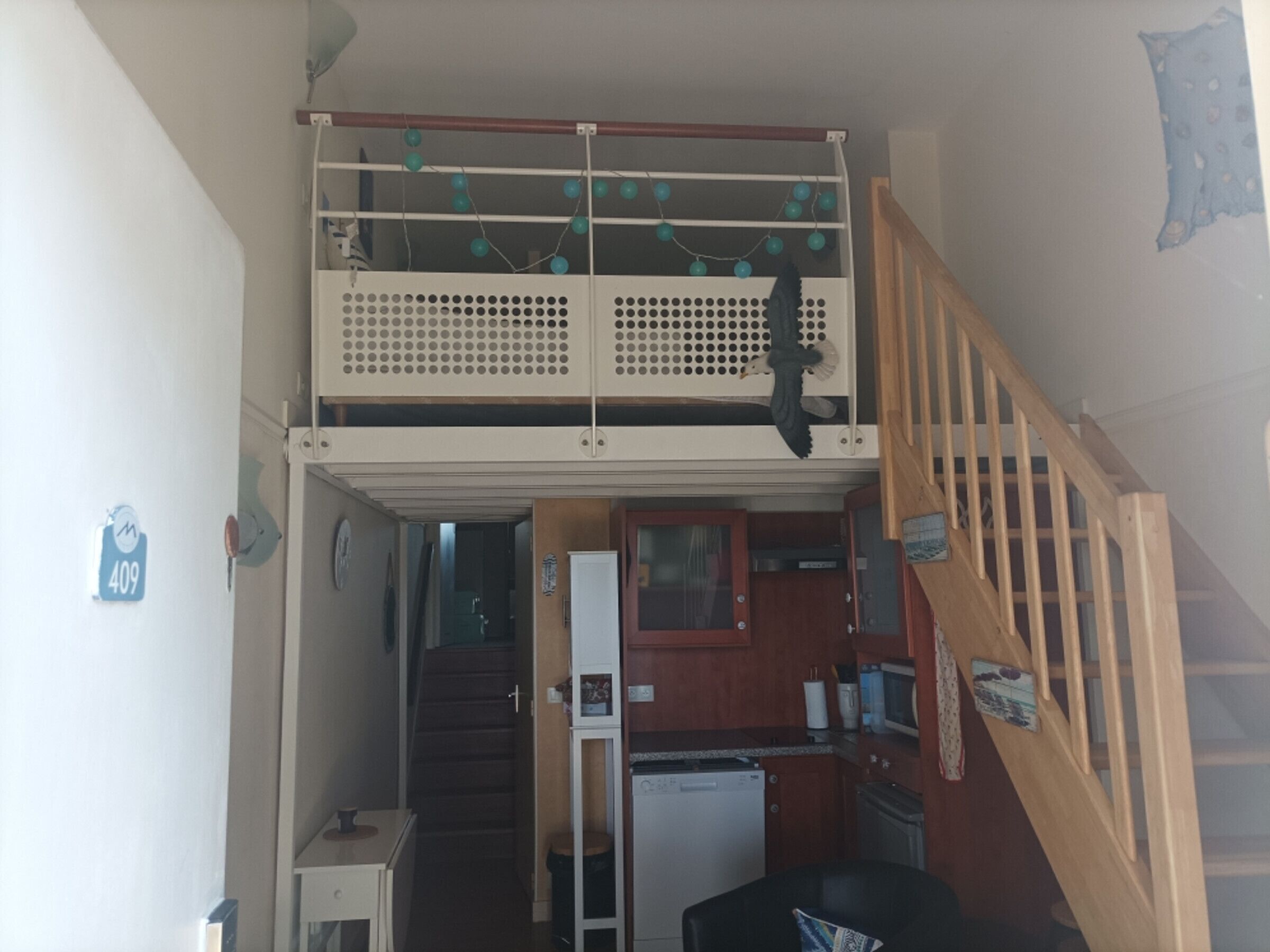 A two-story house with a kitchen on the ground floor and a balcony on the upper floor.