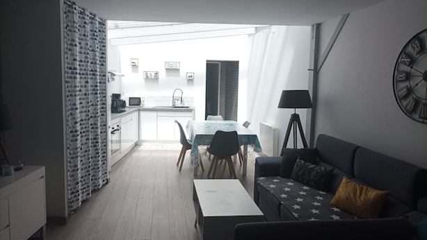 A modern living room with a sofa, a coffee table, and a dining area with a table and chairs. - Quiet house 4-6 pers. near Le Croisic port (Le Croisic)