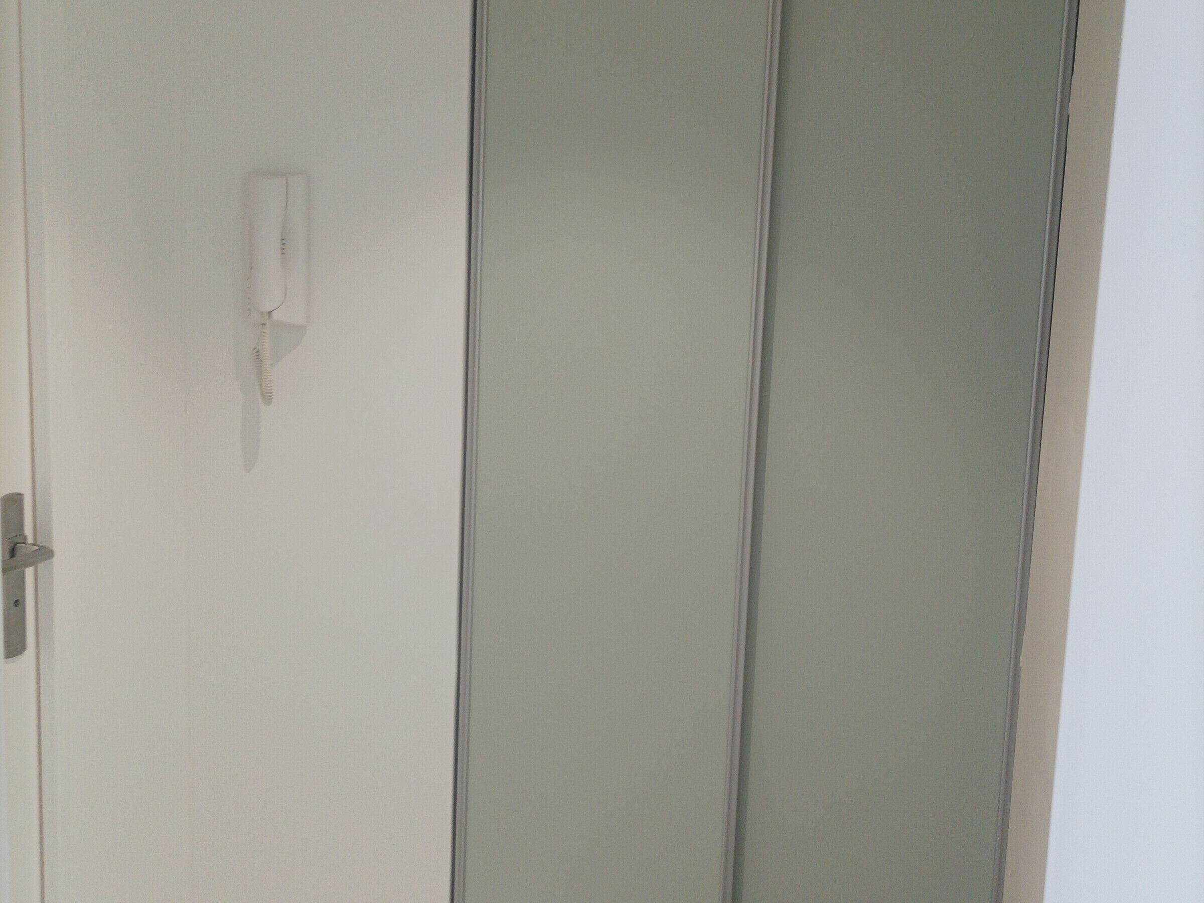 A white door with a telephone mounted on the wall.