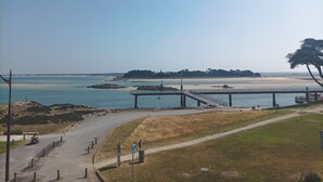 Une vue sur la côte, avec un pont, une plage et une zone herbeuse.