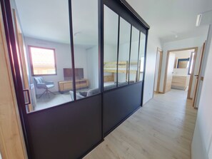 A modern room with a sliding door, a desk, a chair, and a bed. - Spacious Villa Romane for 12, near slopes in Les Rousses (Les Rousses)