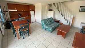 A compact living space with a kitchen, dining area, and a staircase. - Batz-sur-Mer: Duplex Apt 2 Bedrooms, 6 Guests, Parking (Batz-sur-Mer)