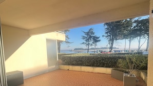 Ein Hotelzimmer mit Fliesenboden, Meerblick und einem Balkon mit Topfpflanzen.