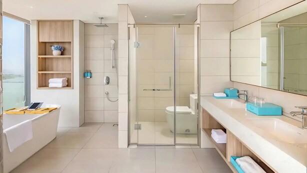A modern bathroom with a glass-enclosed shower, a white toilet, a bathtub, and a vanity with a mirror. - HB serviced Apartment - Ha Long (Bai Chay)