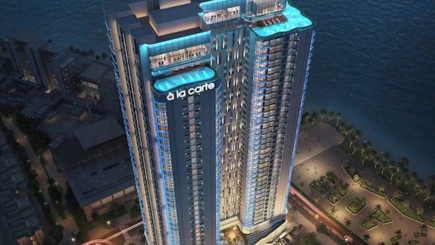 A high-rise hotel with a prominent 'la carte' sign, surrounded by water and greenery. - HB serviced Apartment - Ha Long (Bai Chay)
