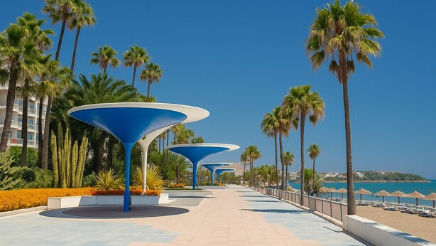 A promenade with palm trees, a clear sky, and a beach in the background. - Charming Maite apartment by the sea with terrace (Estepona)