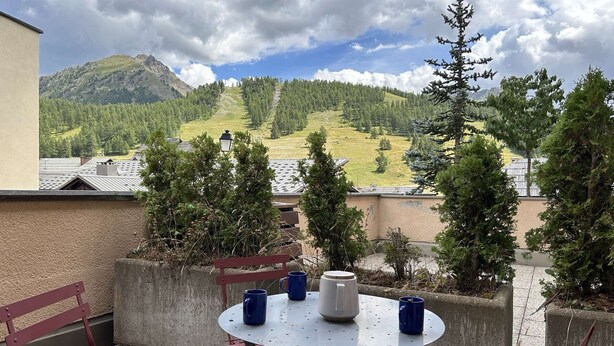 A balcony with a round metal table, two blue mugs, and a white pitcher. - Cozy Montgenèvre apartment, 4 pers, near center (Montgenèvre)